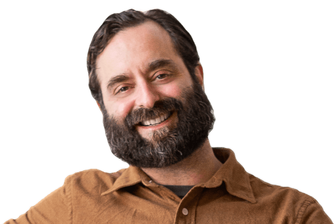 A smiling white man with brown hair and a salt and pepper beard, smiling broadly.