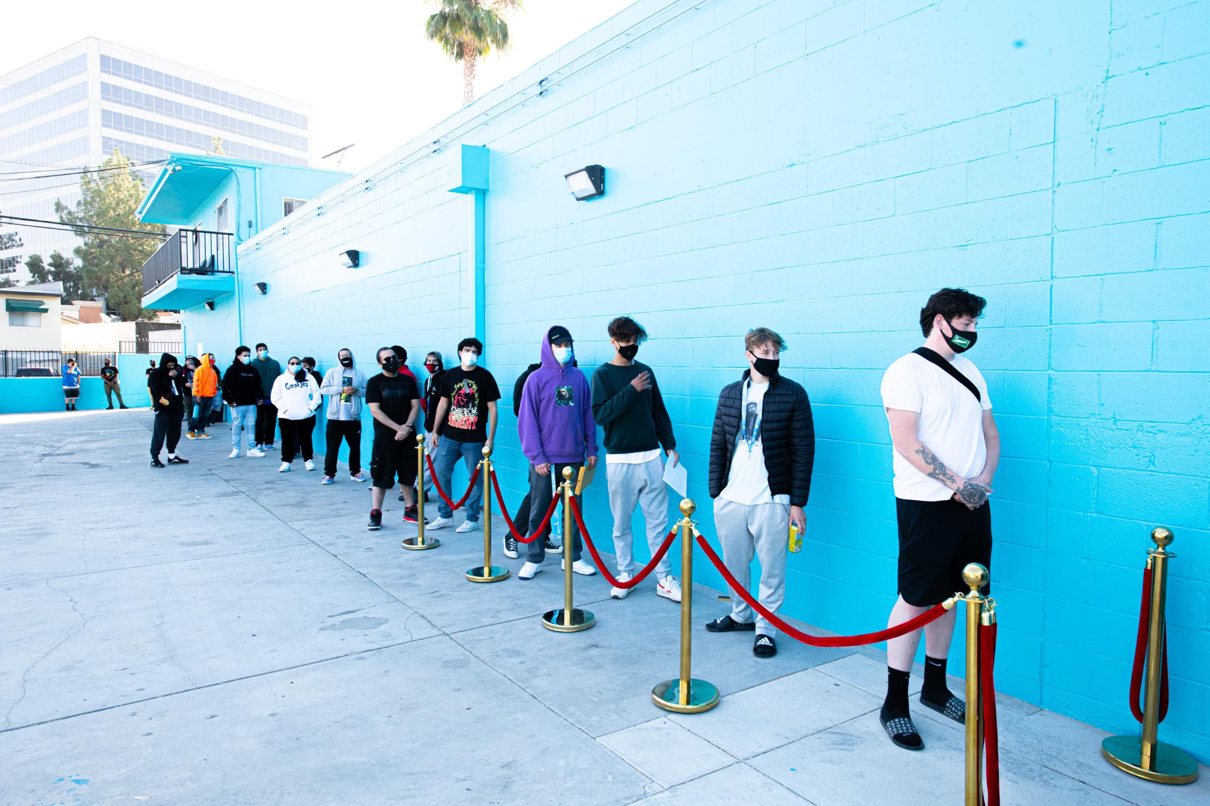 A long line outside a blue-walled dispensary