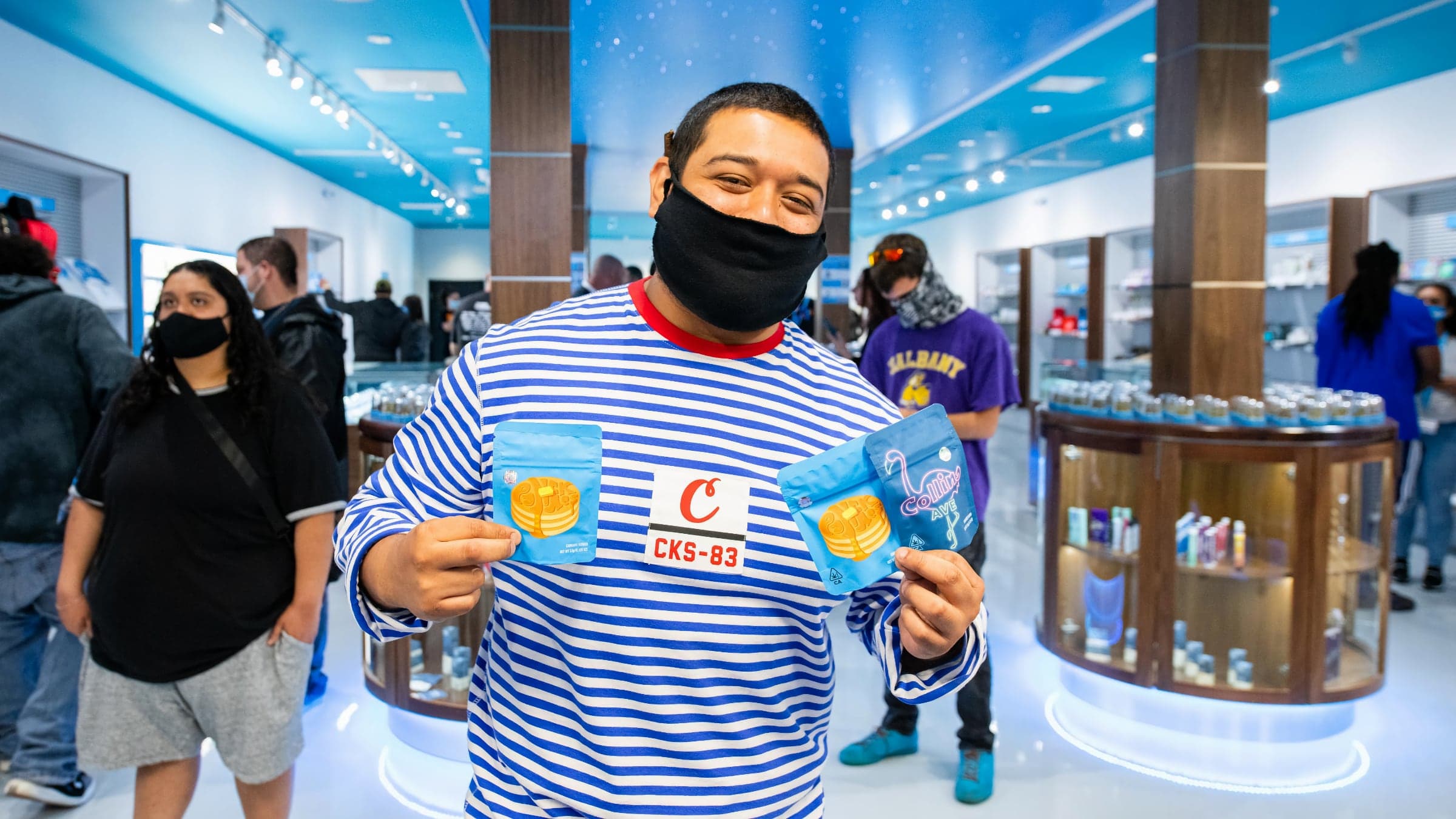A happy man posing with three cannabis products