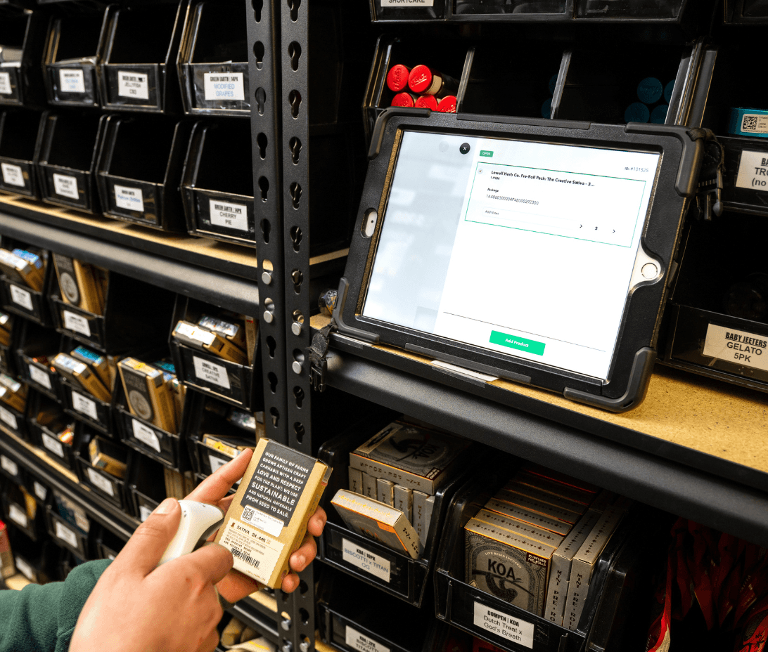 In a well-organized back room of a dispensary, a focused team member is conducting an inventory cycle count using Meadow's software. The room is filled with neatly arranged shelves that house a variety of cannabis products, all labeled and categorized for easy tracking. The staff member scans barcodes on products, efficiently updating the inventory in real-time. The Meadow software interface is visible on the device's screen, showing a user-friendly dashboard that highlights inventory levels, compliance alerts, and sync status with the Metrc track-and-trace system.
This scene embodies the ease and efficiency of staying compliant with Meadow's integrated solutions. It demonstrates how dispensaries can eliminate the hassle of manual inventory checks and data uploads, focusing instead on business growth. The image conveys a sense of confidence and calm, illustrating that with Meadow, dispensaries can effortlessly manage inventory, stay compliant with regulations, and prepare for inspections without stress.
