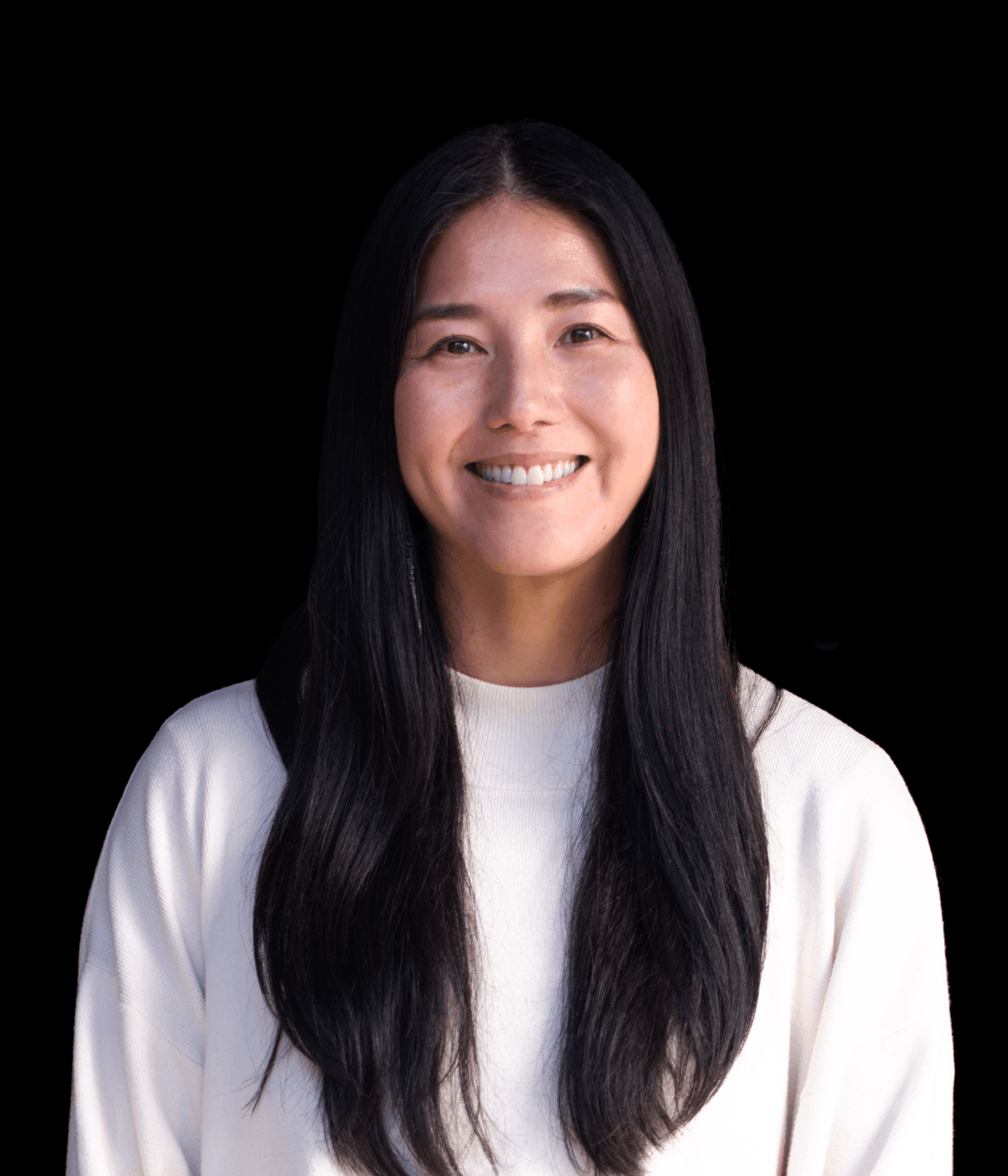 A smiling Japanese woman with long black hair and a white shirt.