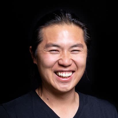A smiling Asian man with black hair.